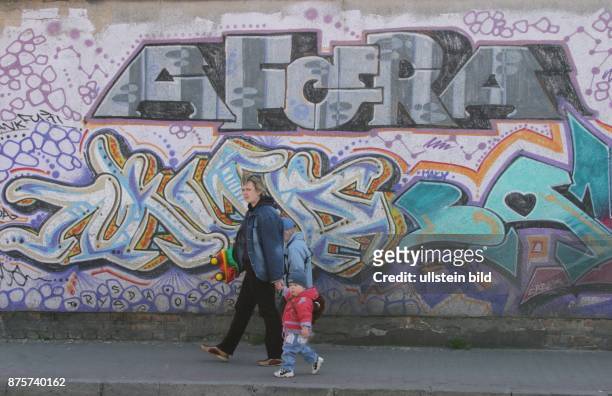 Slubice: Frau mit Kind vor Graffitti-Wand