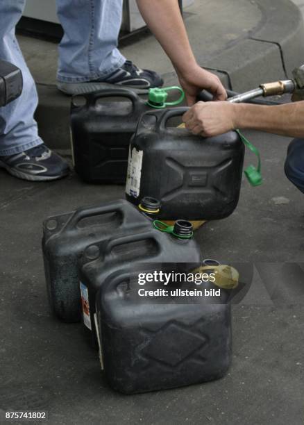 Benzin, Benzinpreis, Ölpreis, Benzinknappheit, Benzinvorräte: Autofahrer füllen Benzinkanister an einer Tankstelle