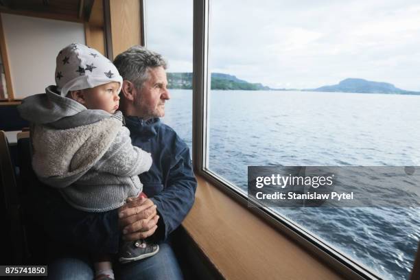 granfather with grandchild looking at ocean from ferry - passagiersboot stockfoto's en -beelden