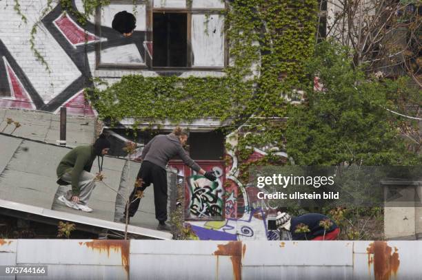 Jungendliche klettern ueber Daecher des abgesperrten Gelaendes des ehemaligen Reichsbahnausbesserungswerkes in Friedrichshain. Stadtbild Bundesbahn...