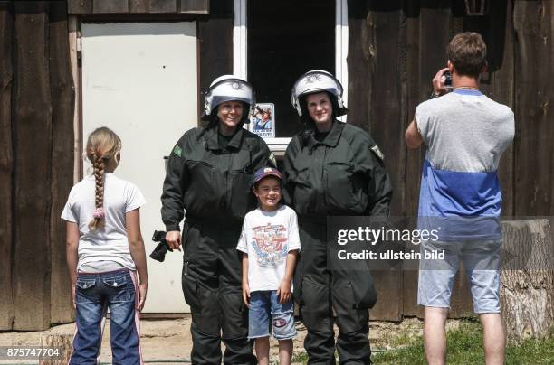 Protestkundgebungen während des G 8 Gipfels in Heiligendamm G 8 Sicherheit Polizei, Mann macht ein Gruppenfoto von zwei Kindern mit Polizistinnen in...