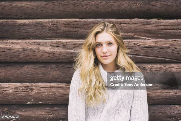 portrait of young woman near log cabin - 16 17 girl blond hair stock pictures, royalty-free photos & images