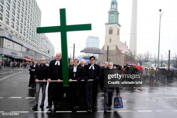 Karfreitagsprozession anlässlich des Osterfestes von der Berliner Marienkriche zum Französischen Dom - Der syrische Flüchtling Jalal Aldebes trägt...