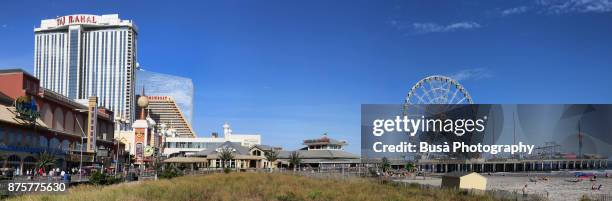 panoramic view of the atlantic city boardwalk, with the hard rock hotel & casino (formerly trump taj mahal) and the will steel pier's observation wheel. atlantic city, new jersey - steel pier stock pictures, royalty-free photos & images