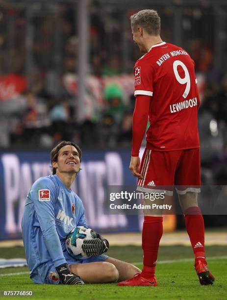 Goalkeeper Marwin Hitz of Augsburg smiles at Robert Lewandowski of Bayern Muenchen during the Bundesliga match between FC Bayern Muenchen and FC...