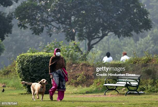 Woman takes her pet dog for a early morning walk, on November 18, 2017 in New Delhi, India. The air was at its cleanest in a month and people in...