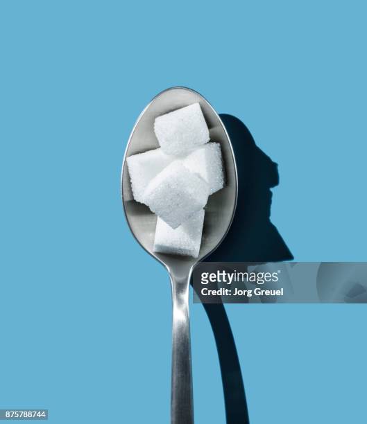 sugar cubes on a spoon - sugar cube stock pictures, royalty-free photos & images