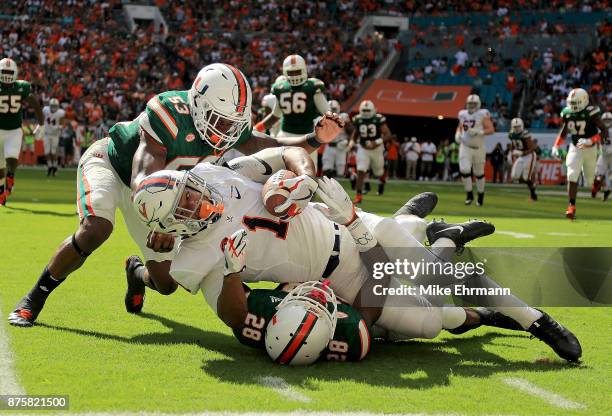 Jordan Ellis of the Virginia Cavaliers makes a catch over Michael Jackson of the Miami Hurricanes during a game at Hard Rock Stadium on November 18,...