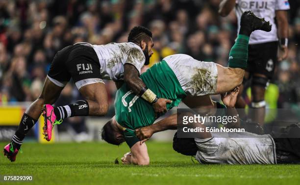 Dublin , Ireland - 18 November 2017; Cian Healy of Ireland is tackled by Ben Volavola, left and Dominiko Waqaniburotu of Fiji during the Guinness...