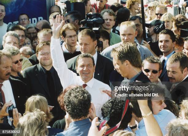 Bundeskanzler Gerhard Schröder beim "Bad in der Menge" auf dem Kanzlerfest in Berlin. Er trägt ein weißes Hemd mit Krawatte und winkt. .