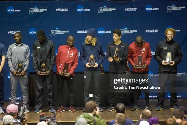 Seven of the top 13 runners stand at the podium with their awards following the Division I Men's Cross Country Championship held at E.P. Tom Sawyer...