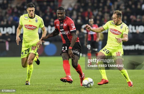 Guingamp's French midfielder Marcus Thuram vies with Angers's Algerian defender Mehdi Tahrat and Angers' French midfielder Flavien Tait during the...
