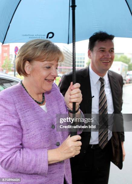 Berlin, CDU PKM Sommerfest: Bundeskanzlerin Angela Merkel und Stefan Mueller CSU mit Regenschirm