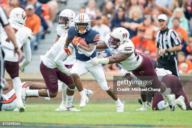 Running back Kam Martin of the Auburn Tigers runs the ball by defensive tackle Derion Ford of the Louisiana Monroe Warhawks at Jordan-Hare Stadium on...