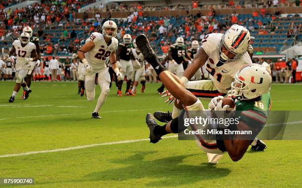 Lawrence Cager of the Miami Hurricanes makes a touchdown catch over Juan Thornhill of the Virginia Cavaliers during a game at Hard Rock Stadium on...