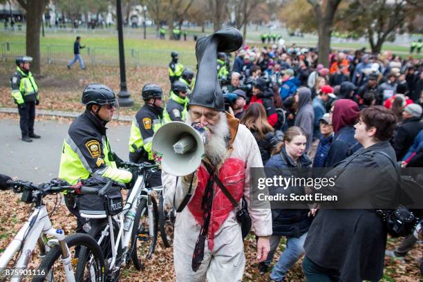 Vermin Supreme speaks to police through his megaphone next to counter-protesters of an Alt-Right organized free speech event on the Boston Common on...