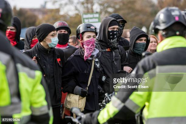 Counter-protesters link arms while facing a wall of bike police outside of an Alt-Right organized free speech event on the Boston Common on November...
