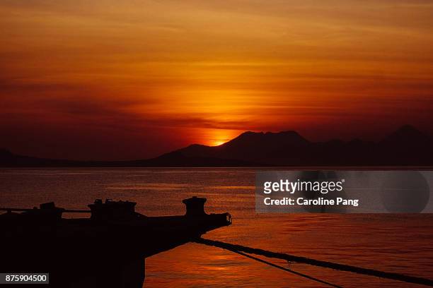 magical hour at the port of ende in flores, indonesia. - caroline pang stockfoto's en -beelden
