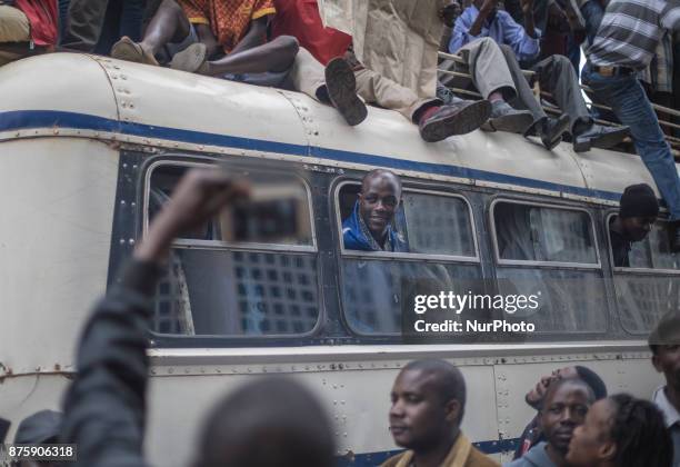 Protesters demanding President Robert Mugabe stand down, look up and cheer as an army helicopter flies over the crowd, as they gather in front of an...