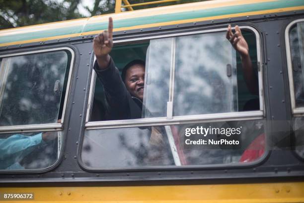 Protesters demanding President Robert Mugabe stand down, look up and cheer as an army helicopter flies over the crowd, as they gather in front of an...