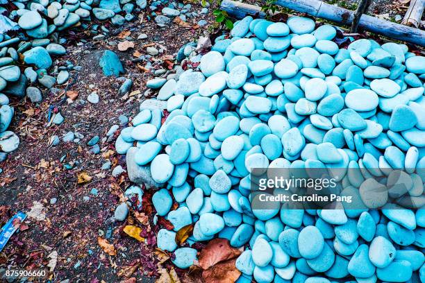 blue and torquiose coloured stones on a stretch of beach along the road from ende to bajawa in flores indonesia. - caroline pang stock-fotos und bilder