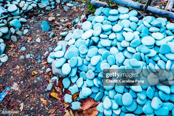 blue and torquiose coloured stones on a stretch of beach along the road from ende to bajawa in flores indonesia. - caroline pang stockfoto's en -beelden