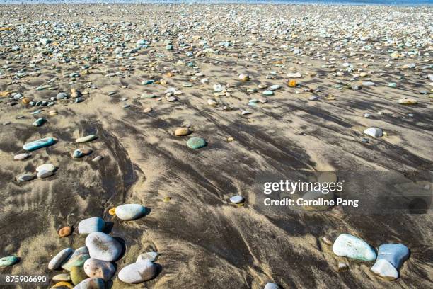 blue and turquoise coloured stones on a stretch of beach along the road from ende to bajawa in flores indonesia. - caroline pang stock-fotos und bilder