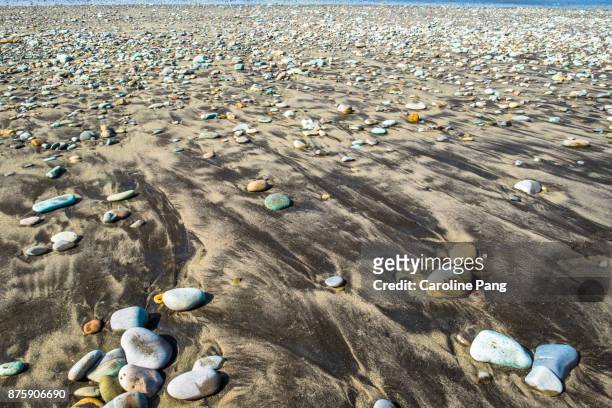 blue and turquoise coloured stones on a stretch of beach along the road from ende to bajawa in flores indonesia. - caroline pang stock pictures, royalty-free photos & images
