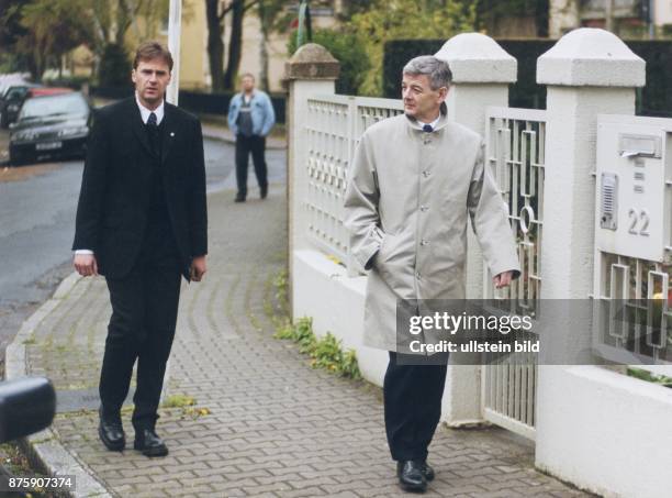 Bundesaußenminister Joschka Fischer im Trenchcoat auf dem Weg zu seiner Hochzeit mit Nicola Leske. Ihm folgt ein Sicherheitsbeamter. .