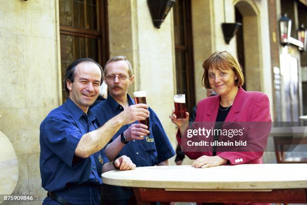 Die CDU-Generalsekretärin Dr. Angela Merkel erhebt ihr Glas Altbier mit zwei Männern an einem Stehtisch in Düsseldorf. .