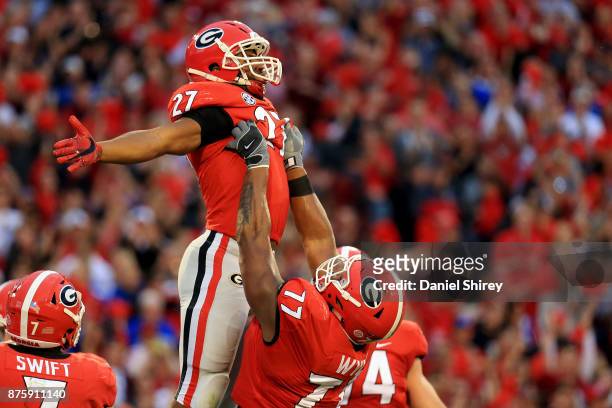 Nick Chubb celebrates a touchdown with Isaiah Wynn of the Georgia Bulldogs during the first half against the Kentucky Wildcats at Sanford Stadium on...
