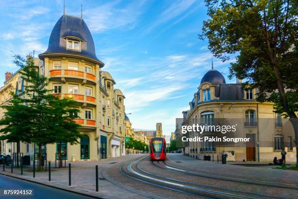tram on the streets and architecture of reims a city in the champagne-ardenne region of france. - tramway reims stock pictures, royalty-free photos & images