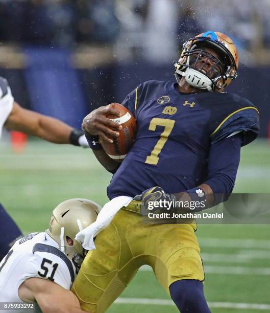 Brandon Wimbush of the Notre Dame Fighting Irish is tackeld by Winn Howard of the Navy Midshipmen at Notre Dame Stadium on November 18, 2017 in South...