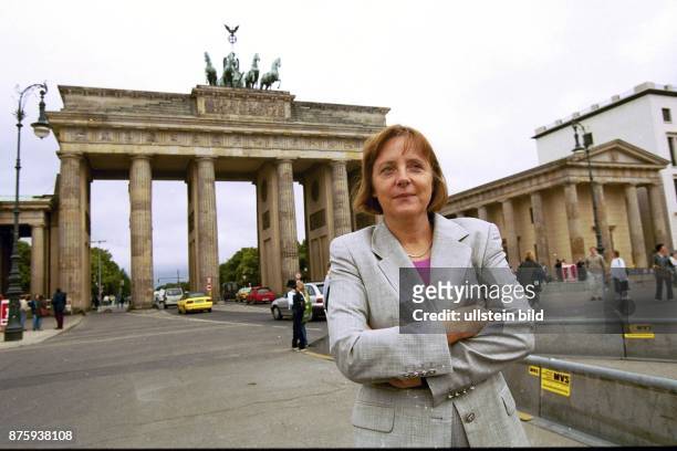 Die Generalsekretärin der CDU Dr. Angela Merkel steht mit verschränkten Armen vor dem Brandenburger Tor. .