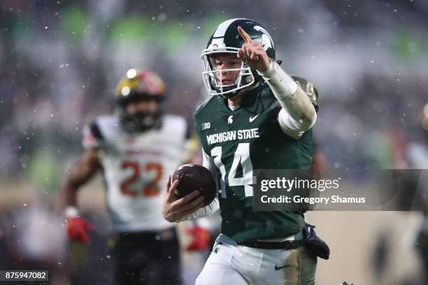 Brian Lewerke of the Michigan State Spartans runs for a first half touchdown in front of Isaiah Davis of the Maryland Terrapins at Spartan Stadium on...