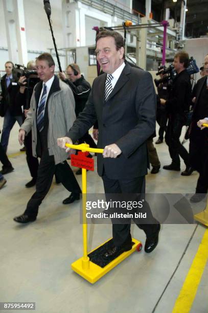 Politiker, SPD; D Bundeskanzler seit 1998- Besuch der Firma SKL Motor in Magdeburg fährt mit gelbem Tretroller durch die Produktionshalle