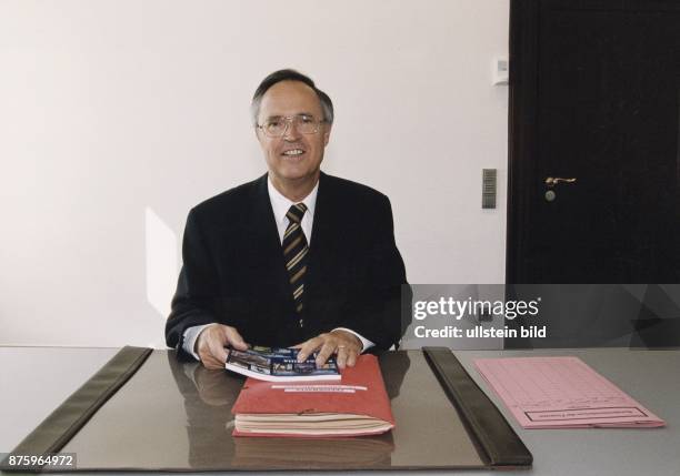 Bundesfinanzminister Hans Eichel sitzt am Schreibtisch in seinem Büro in Berlin. In den Händen hält er einen Katalog, der auf einem Aktenordner...