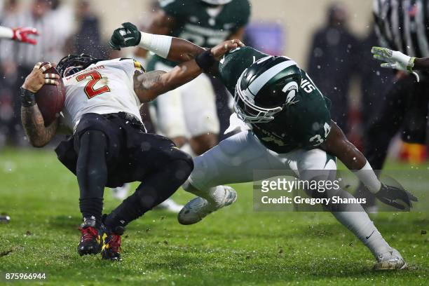Lorenzo Harrison III of the Maryland Terrapins is tackled by Antjuan Simmons of the Michigan State Spartans during a first half run at Spartan...