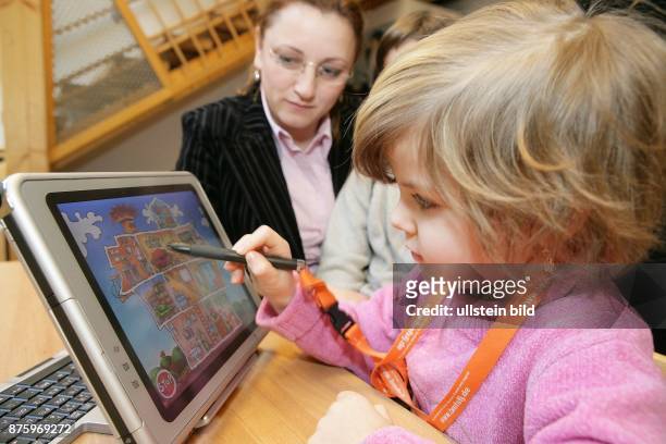 Lernen im Vorschulalter, Microsoft Schlaumaeuse, Mädchen am Schlaumaeuse Computer, einem Tablet PC, an dem die Kinder interaktiv Buchstaben und...