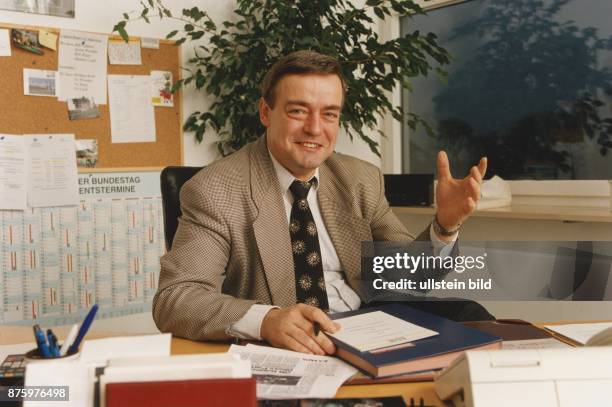 Uwe Lühr, FDP-Bundestagsabgeordete von Sachsen-Anhalt sitzt im Büro am Schreibtisch vor einer Pinnwand. Undatiertes Foto.