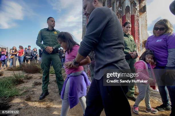 Ashley and Aubrey Luna walk away with their Dad Luis Luna Diaz after seeing his wife Arael Moreno Rivera on the Miexico side through an open gate on...