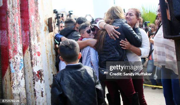 Family members embrace as they meet their loved ones through an open gate along the U.S. Mexico border November 18, 2017 in San Ysidro, California....