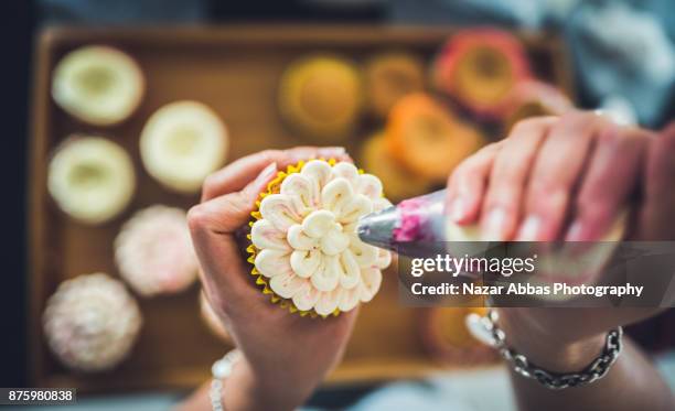 woman decoration cupcakes. - decorar um bolo imagens e fotografias de stock