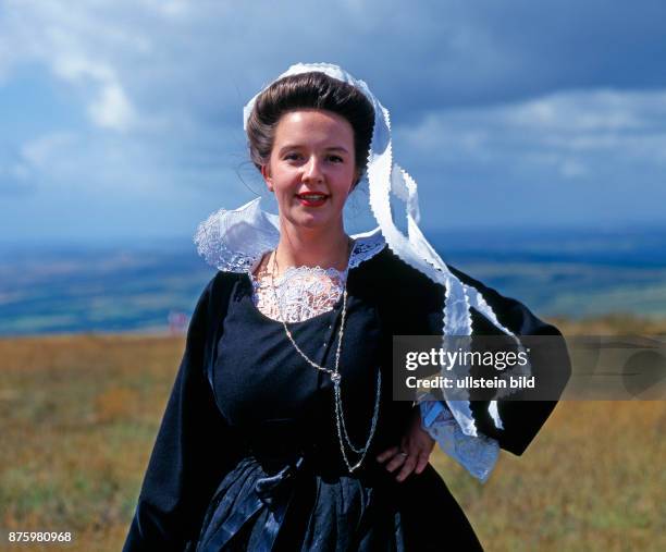 Junge schoene Frau in traditioneller bretonischer Tracht mit gestaerkter Halskrause aus der Region Pont Aven, die nur noch zu festlichen Anlaessen...