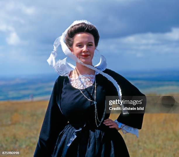 Junge schoene Frau in traditioneller bretonischer Tracht mit gestaerkter Halskrause aus der Region Pont Aven, die nur noch zu festlichen Anlaessen...