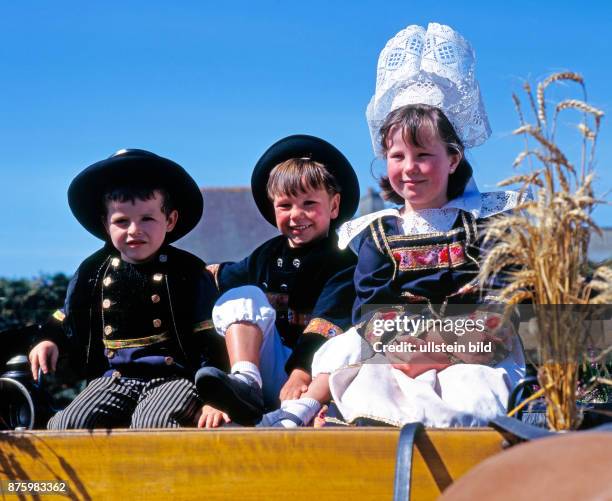 Kinder auf geschmueckter Kutsche und in traditioneller bretonischer Tracht, die in der Landschaft Finistere nur noch zu festlichen Anlaessen, wie...