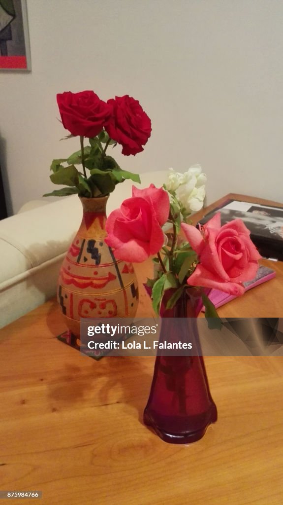 Red roses and pink roses on vases at home