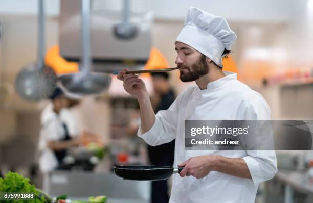 chef-kok in een restaurant proeverij een saus die hij net bereid - chef smelling food stockfoto's en -beelden