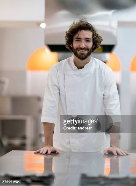 portrait of handsome young chef looking at the camera smiling - handsome people stock pictures, royalty-free photos & images