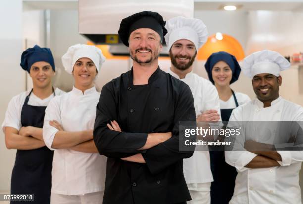 proud team of chef, sous chefs and cooking assistants looking at camera smiling - indian chef stock pictures, royalty-free photos & images